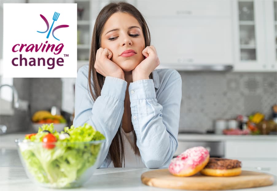 woman looking at salad and doughnuts in front of her